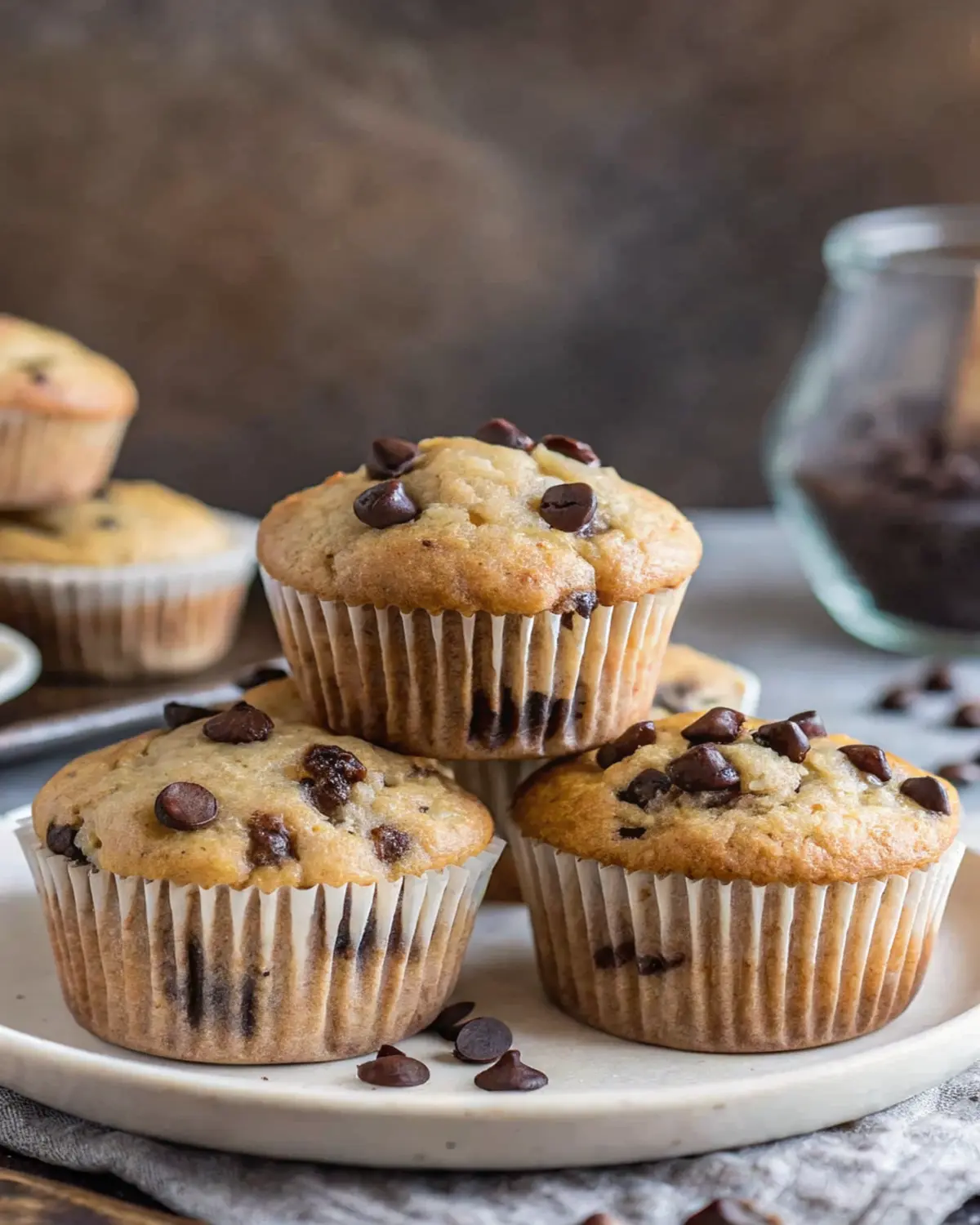 baking-with-protein-powder-muffins Homemade protein muffins with chocolate chips on a white plate