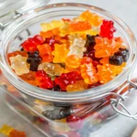 Glass jar filled with colorful homemade healthy jelly sweets shaped like gummy bears
